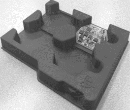Portion de blister, emballage imprimé en 3D de couleur noire. Constitué de 4 alvéoles visibles dont une contenant une petite carte électronique.
