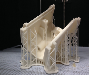 Pièce mécanique imprimée en 3D en stéréo-lithographie. La pièce est blanche mesure environ 8cm par 5 par 5. Les supports d'impression sont encore présents.